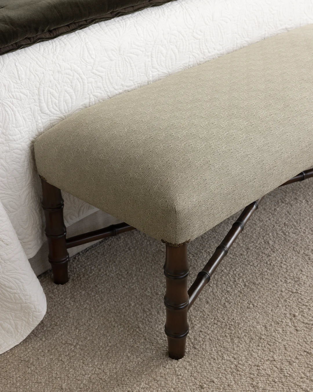 Close up of faux bamboo bench with custom upholstery