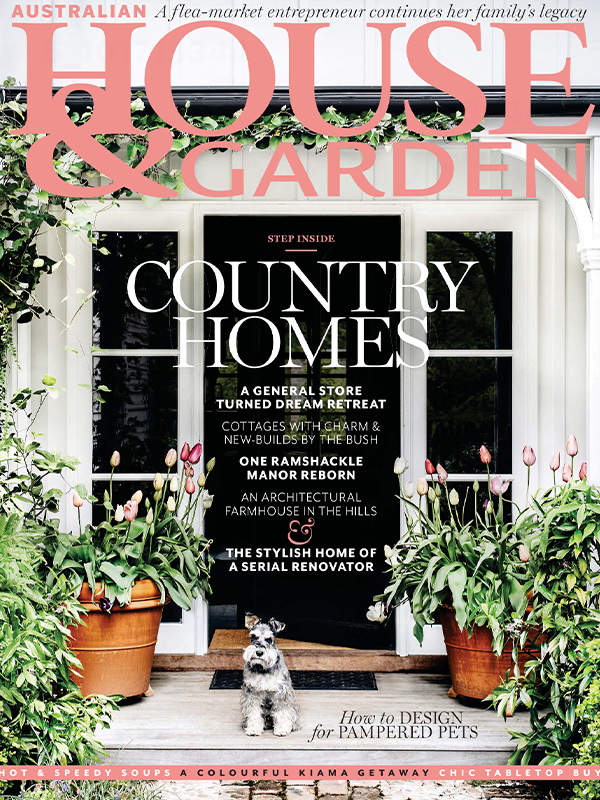 Front cover of House & Garden magazine featuring a white house facade with a black door, large coral title text at the top, and a small dog standing in front of the doorway. The cover includes article titles such as Country Homes and How to Design for Pampered Pets.