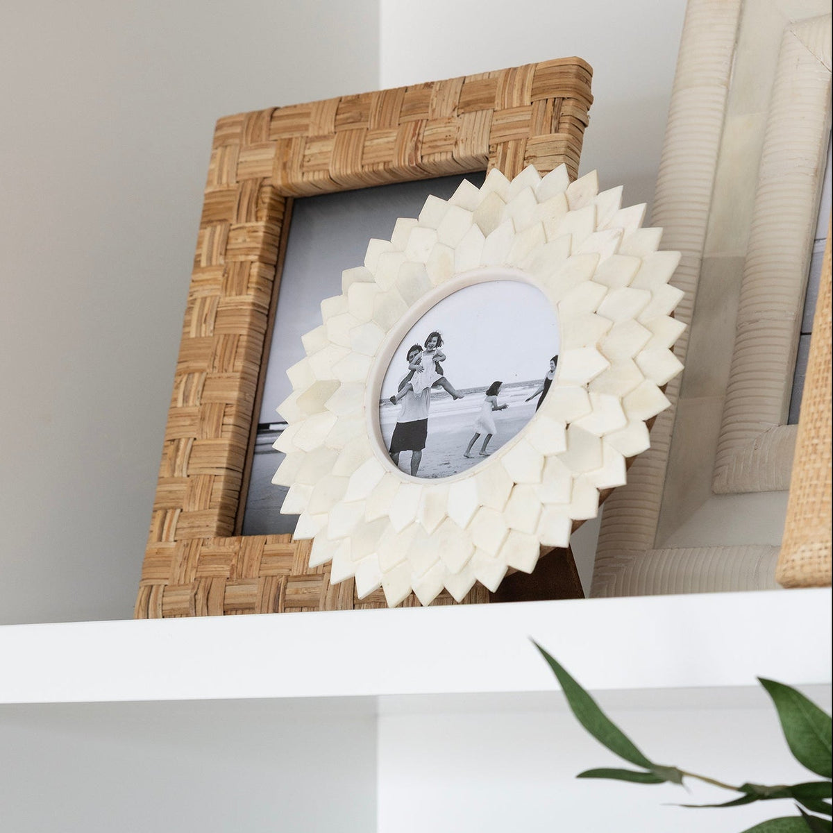 Two photo frames sitting on a shelf