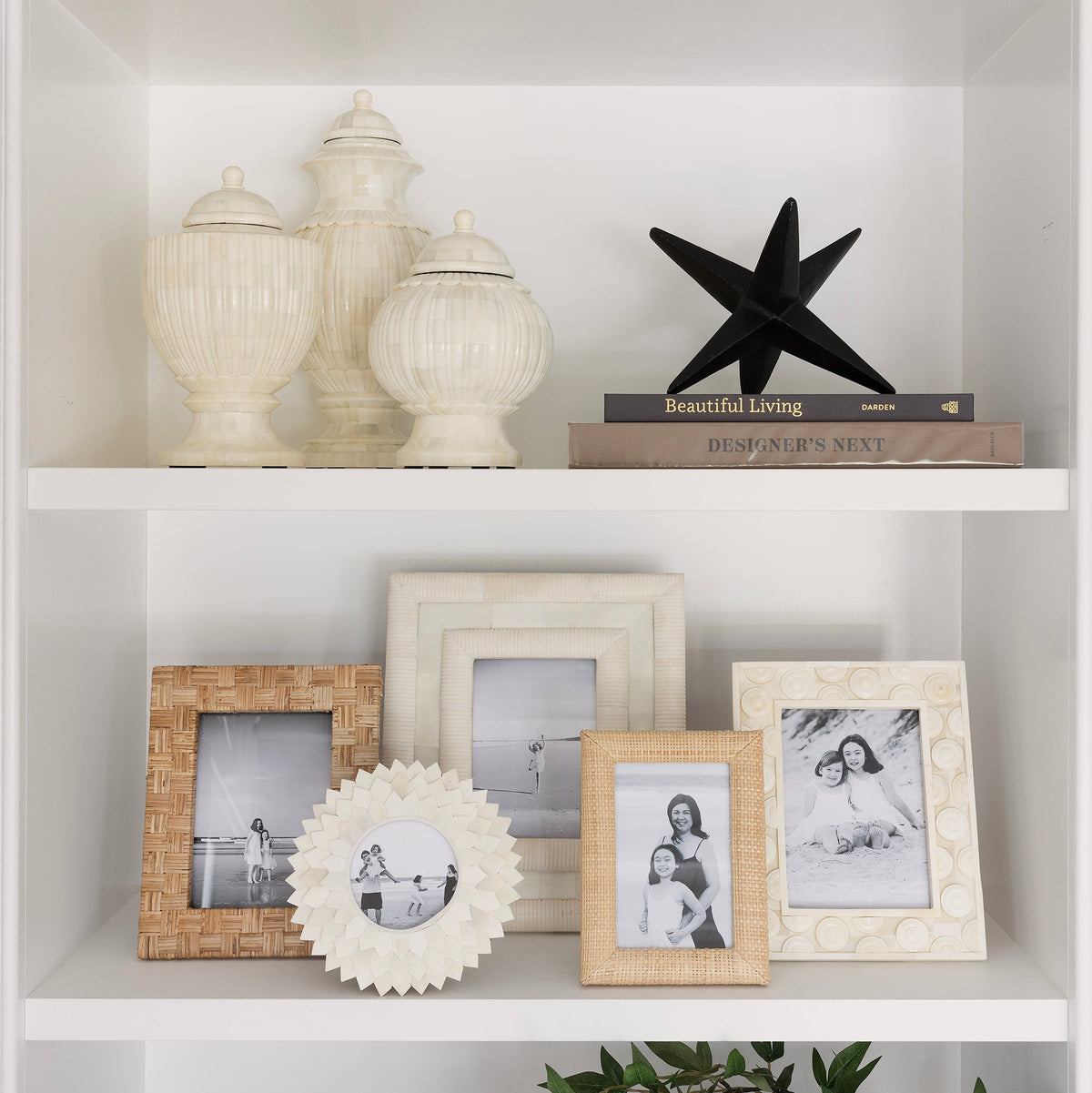 Decorative shelf with various items including framed photos, a starfish, and decorative vases.