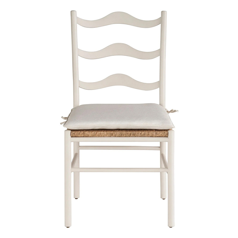 White chair with wave back detail, rattan seat and removable seat cushion with ties in a neutral white fabric.