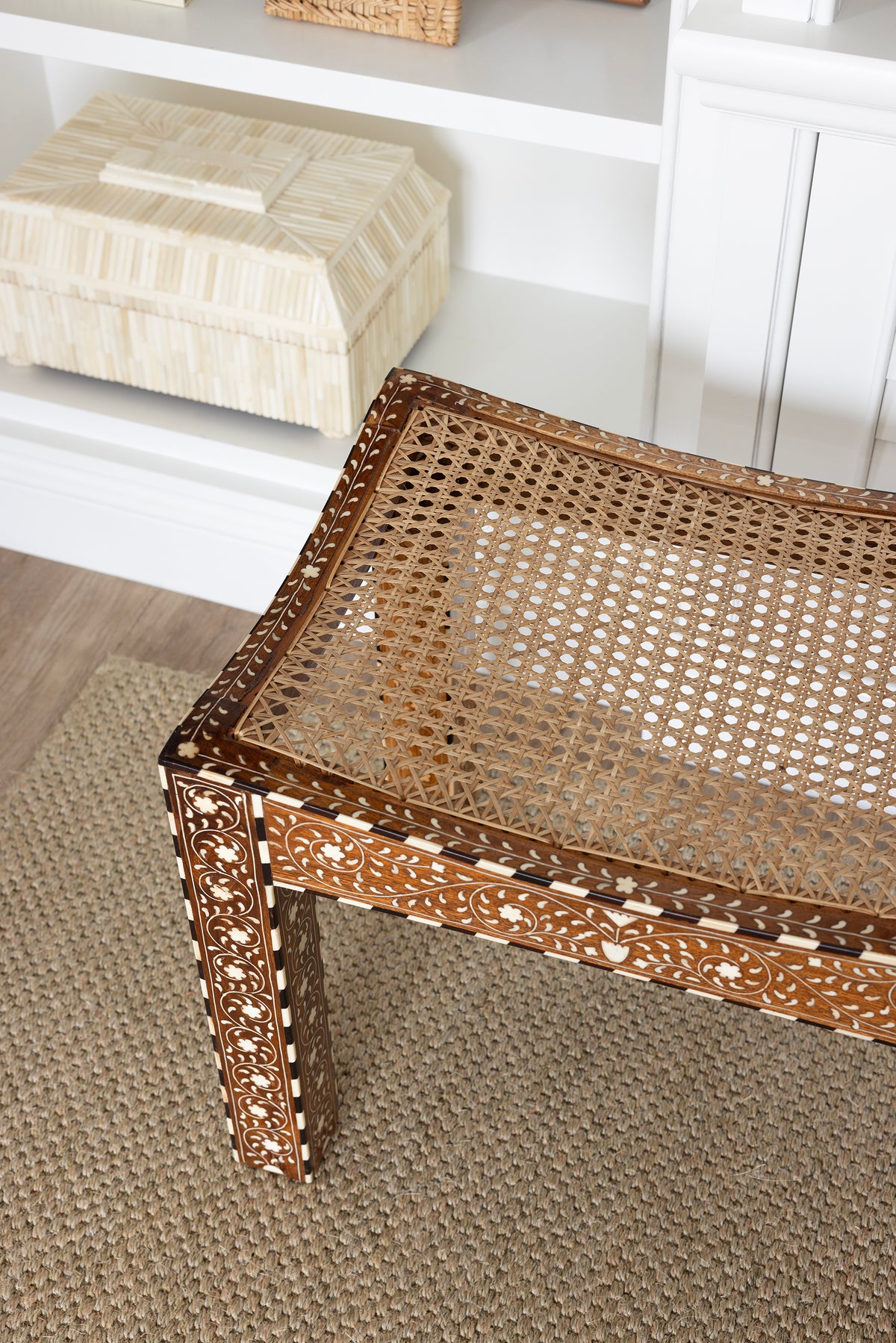 Rattan and intricate bone inlay ottoman on a sisal rug