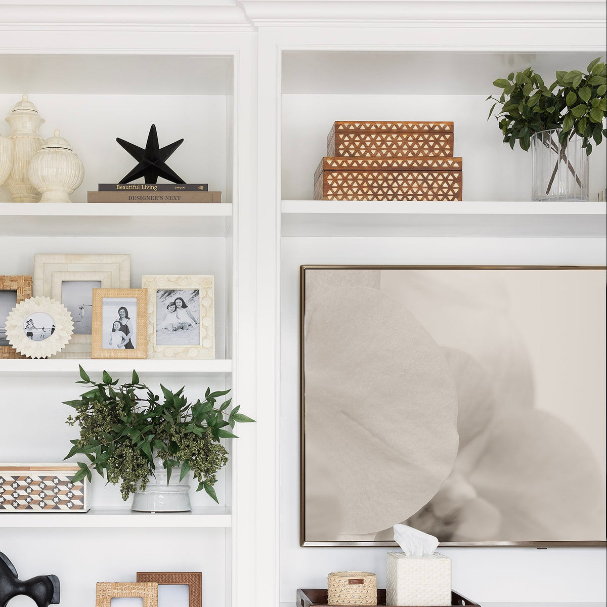White built-in bookshelf with decorative items in a room with wooden floor and white walls.