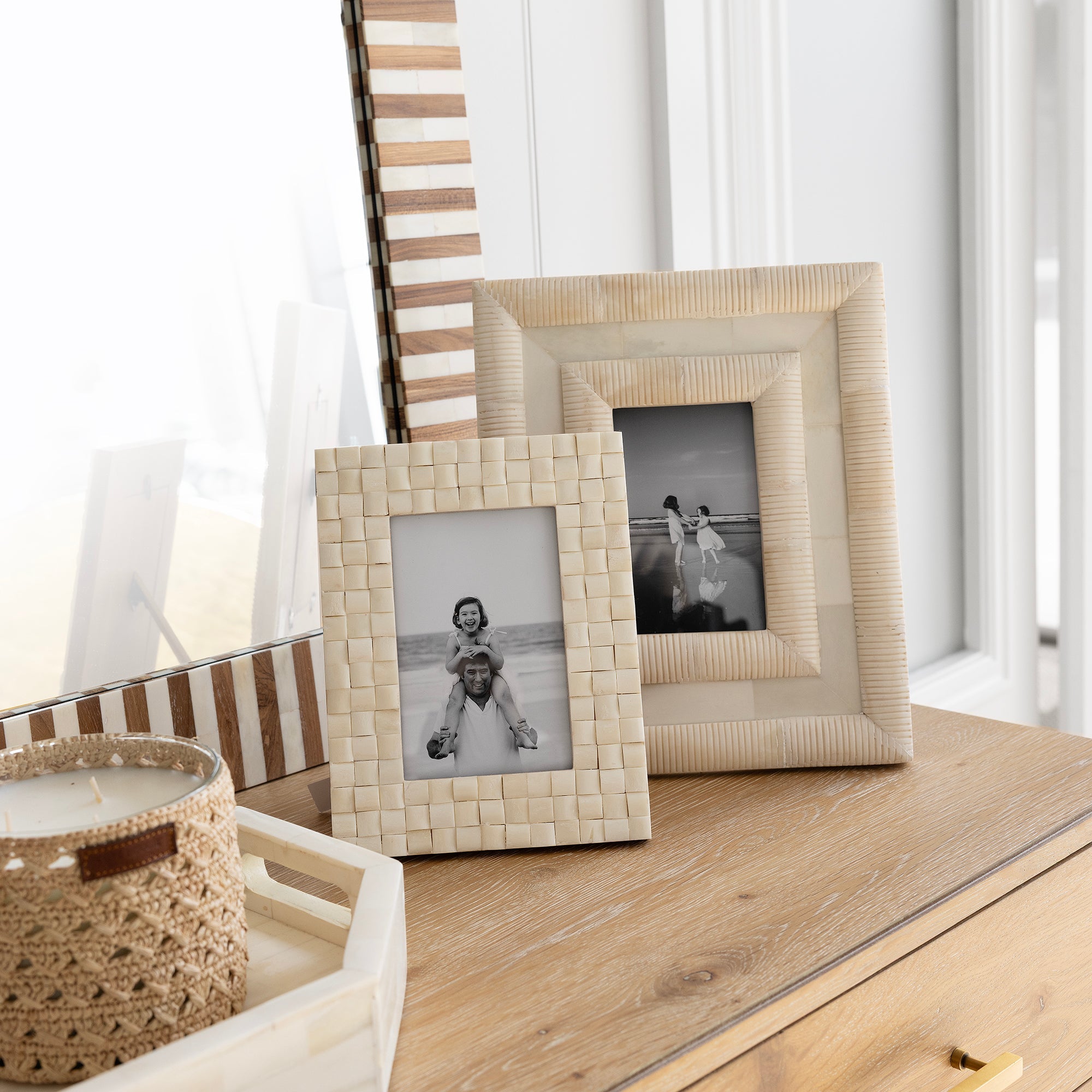Decorative table with woven picture frames and a candle