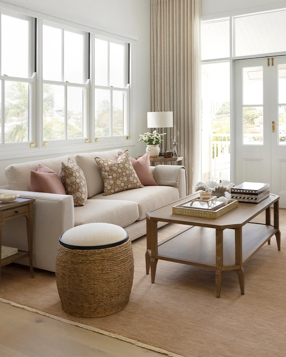 Living room with neutral sofa, woven ottoman, oak coffee table 