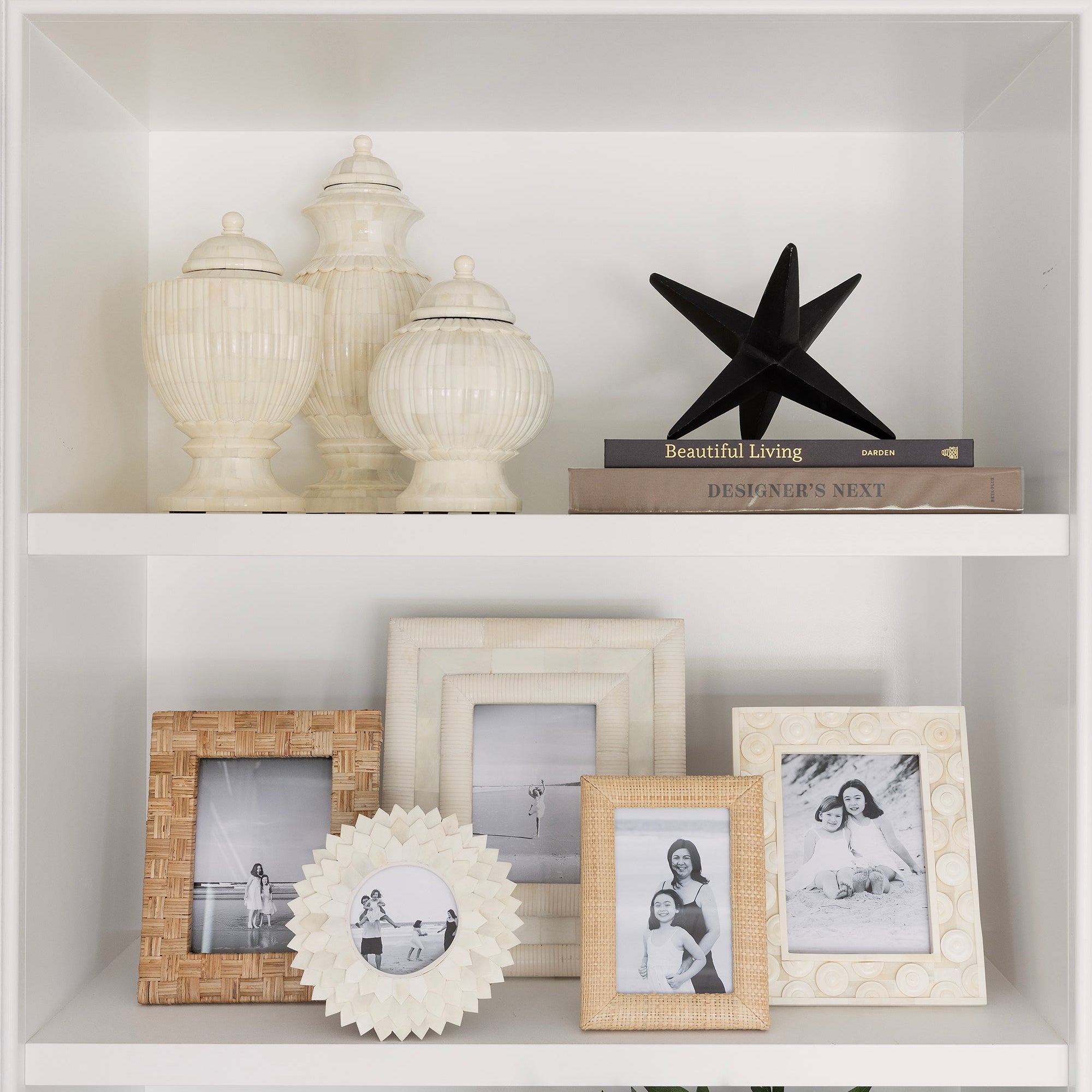 Decorative shelf with various items including framed photos, a jack sculpture, and decorative vases.