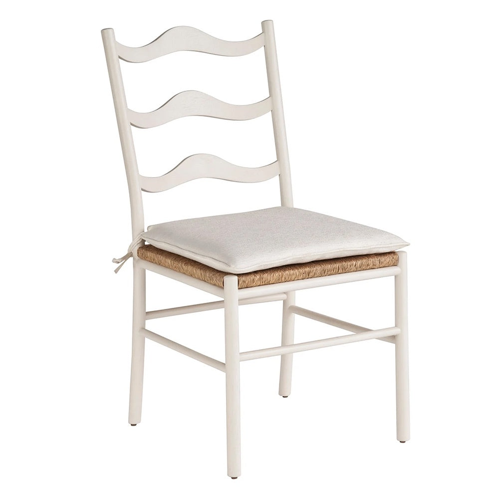 White chair with wave back detail, rattan seat and removable seat cushion with ties in a neutral white fabric. 